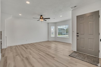 Entrance foyer featuring light wood finished floors, recessed lighting, ceiling fan, and a textured ceiling