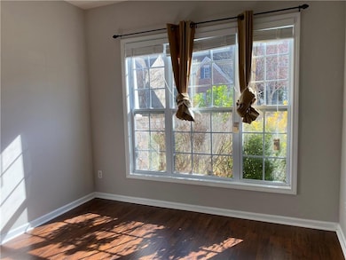 Unfurnished room with baseboards and dark wood-style flooring