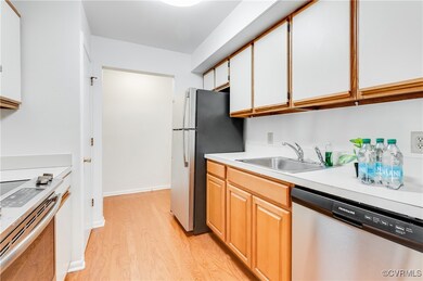 Kitchen featuring white cabinetry, sink, stainless