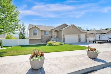 Ranch-style home featuring stucco siding, stone siding, a garage, and concrete driveway