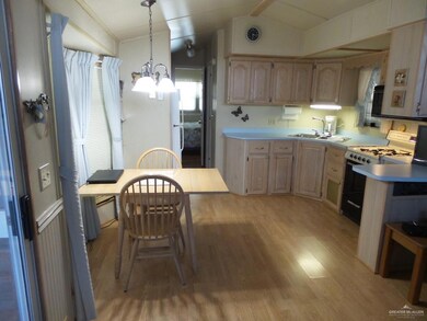 Kitchen area with dining space plus bar area.  Kitchen sink window and under cabinet light.