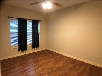 Spare room with dark wood-style flooring and ceiling fan