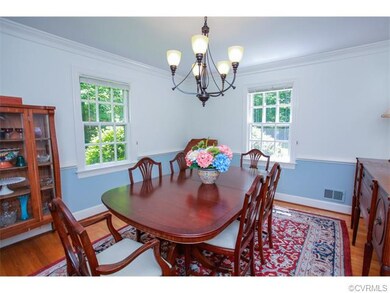 The formal dining area has hardwood flooring, crow