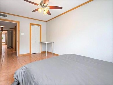 Bedroom with crown molding, baseboards, tile patt