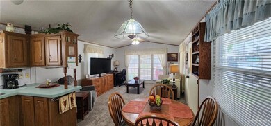 Carpeted dining area featuring vaulted ceiling, a textured ceiling, and ceiling fan