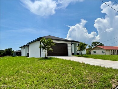 View of front facade featuring stucco siding, driv
