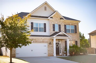 Craftsman-style home with driveway, a garage, bric