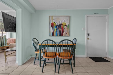 Dining area featuring baseboards, light tile patterned flooring, and ornamental molding