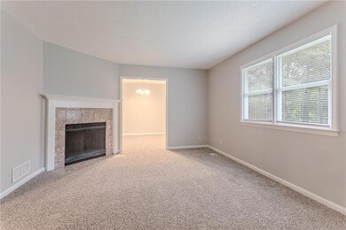 Unfurnished living room with carpet flooring, baseboards, a tile fireplace, and a textured ceiling