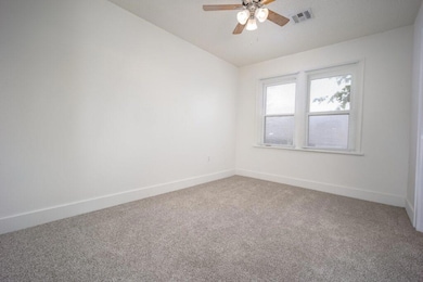 Carpeted spare room with baseboards and a ceiling fan