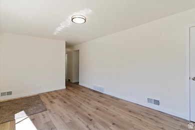 Unfurnished room with light wood-style flooring and baseboards
