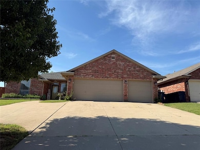 Single story home with a garage, driveway, and brick siding