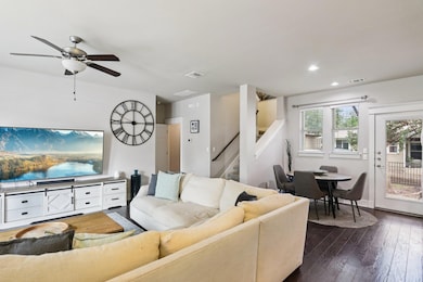 Living area featuring dark wood-style floors, a ceiling fan, recessed lighting, and stairway