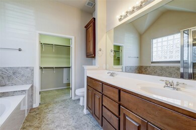 Bathroom featuring a garden tub, double vanity, v