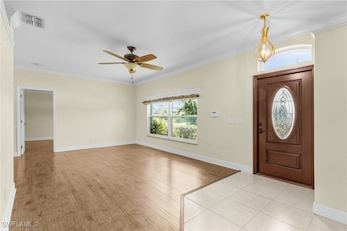Foyer entrance with ornamental molding, a ceiling