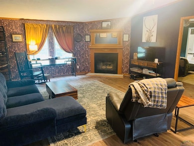 Living area featuring wallpapered walls, wood fini