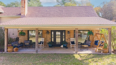 Rear view of house featuring brick siding, a lawn, and a chimney