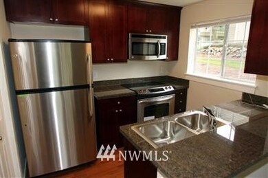 Granite counter, stainless appliances, cherry cabinets, and wood floors create a clean and modern feel to a wonderful kitchen.