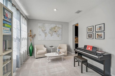 This inviting office or den offers a bright and versatile space, perfect for reading, music, or quiet conversation. Soft carpeting, large windows with sheer drapes, and neutral tones create a warm and welcoming atmosphere. The piano adds a creative touch, while the adjacent butler’s pantry enhances functionality.