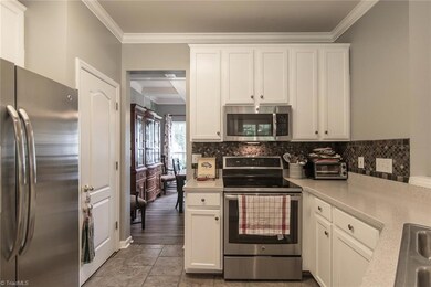 Cute kitchen with tile flooring and extended white cabinets