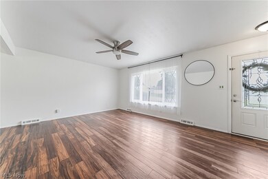 Unfurnished living room featuring dark hardwood / wood-style flooring and ceiling fan