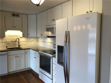 Custom-made white wood shaker kitchen features sof