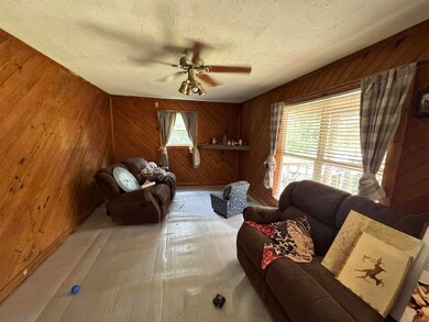 Living room with a textured ceiling, ceiling fan, 