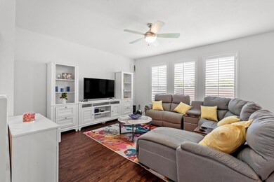 Living area with a ceiling fan and dark wood-styl