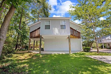 View of back of house featuring a front yard, a patio, a wooden deck, and central AC
