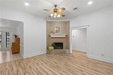 Unfurnished living room featuring ceiling fan, orn