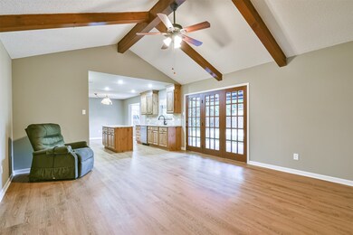 FAMILY ROOM/DEN WITH CATHEDRAL CEILING AND WOOD BEAM ACCENTS.  EXTENSIVE WOOD LOOK LVP FLOORING.