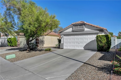 View of front facade with stucco siding, a garage, a tile roof, and concrete driveway
