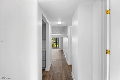 Hallway with dark wood-style floors and baseboards