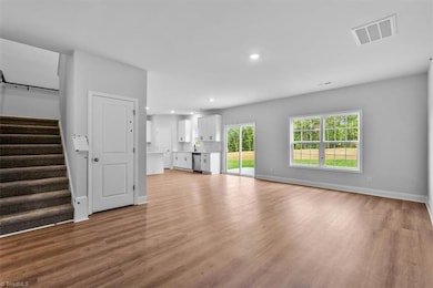 View of open living room/dining area/ kitchen from entry. Cloak closet offers additional storage.