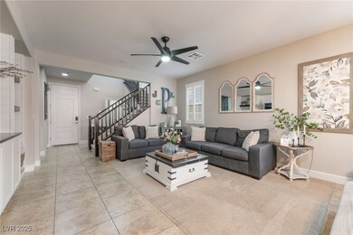 Living area featuring stairway, a ceiling fan, and