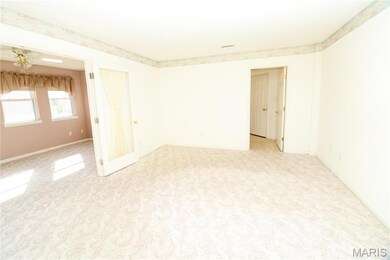 Spare room featuring light colored carpet and a ceiling fan