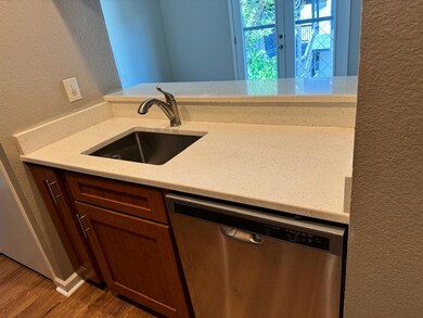 Kitchen featuring dishwasher, a textured wall, wo