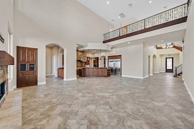 Unfurnished living room with arched walkways, a hi
