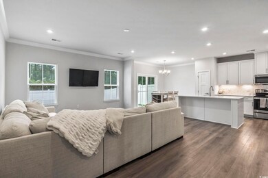 Living room with ornamental molding, dark hardwood
