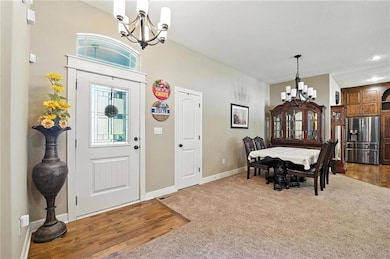 Entryway featuring a chandelier, wood finished floors, and carpet floors