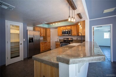 Kitchen with sink, a textured ceiling, pendant lig
