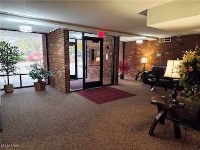 Building lobby featuring brick wall and a textured ceiling
