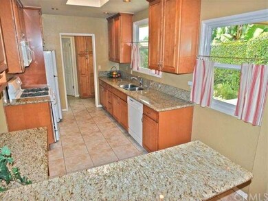 Kitchen has granite counters, maple cabinets, skyl