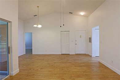 Unfurnished room with high vaulted ceiling, light