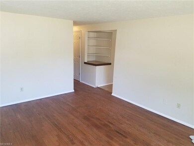 Living room with hardwood flooring, built-in shelv
