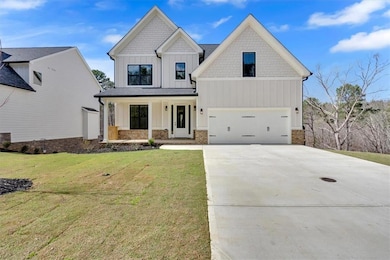 View of front of house featuring driveway, stone s