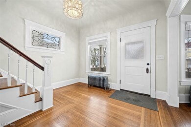 Entrance foyer featuring a chandelier, dark hardwood / wood-style flooring, and radiator heating unit