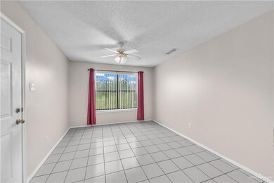 Empty room with ceiling fan and a textured ceiling