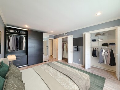 Bedroom showing a wall of closets with custom armo