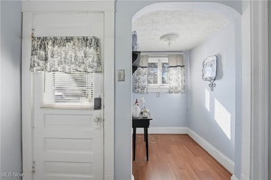 Doorway featuring wood finished floors and a textured ceiling